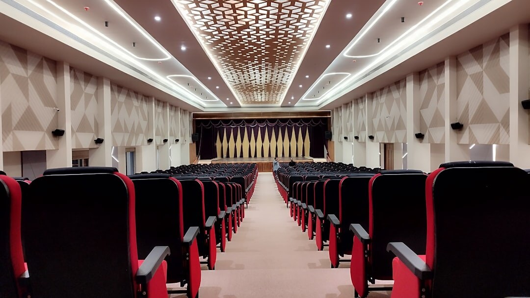 Empty conference hall with rows of chairs facing a stage